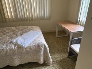 a bedroom with a bed and a desk and a window at Dalby home in Dalby