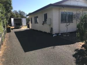 a house with a large driveway in front of it at Dalby home in Dalby