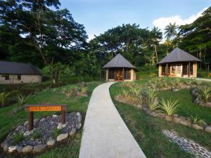 a walkway leading to two gazebos in a resort at Taveuni Dive Resort in Waiyevo