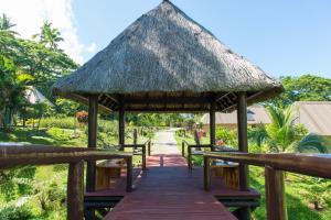 a pavilion with benches and a thatched roof at Taveuni Dive Resort in Waiyevo