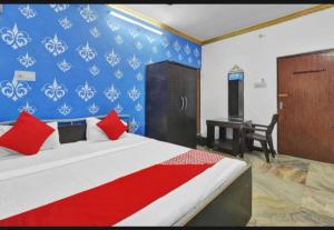 a bedroom with a bed with red pillows and a desk at RROOMS Eco Hotel Best in Lucknow