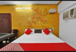 a bedroom with a bed with a tree painted on the wall at RROOMS Eco Hotel Best in Lucknow
