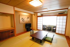 a living room with a table and a dining room at Fuji Yamanakako Hotel in Yamanakako