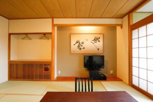 a living room with a tv and a table at Fuji Yamanakako Hotel in Yamanakako +11 photos