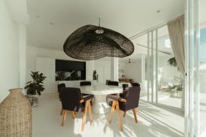 a dining room with a white table and chairs at The Iggy Villa 2BR in Cemagi