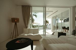 a living room with white furniture and a large window at The Iggy Villa 2BR in Cemagi