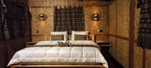 a bedroom with a large white bed in a room at Tetebatu Sasak House Bungalow in Tetebatu +45 photos