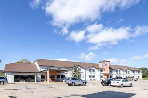 un hotel con coches estacionados en un estacionamiento en Motel 6-Waterloo, IA, en Waterloo