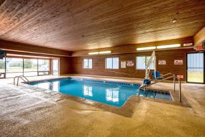 a large swimming pool in a room with a wooden ceiling at Motel 6-Waterloo, IA in Waterloo