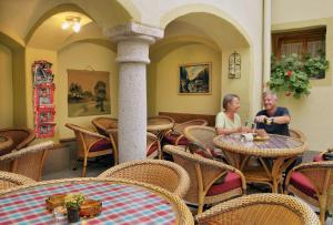 dos personas sentadas en una mesa en un restaurante en Pension Martha, en Grein