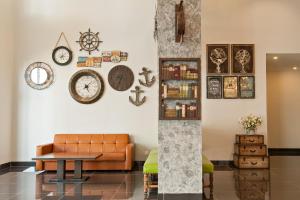 a living room with a couch and clocks on the wall at Hotel Arissa in Melaka