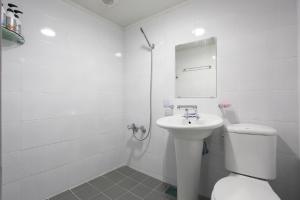 a white bathroom with a toilet and a sink at G Mini Hotel Dongdaemun in Seoul