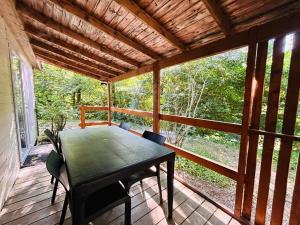 a screened in porch with a table and chairs at Camping L'Amandier in Gigors