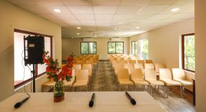 a conference room with white chairs and tables and a tv at River Whisper Villa in Cochin +62 photos