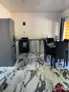 a kitchen and dining room with a marble floor at Ramachi Apartment A in Livingstone