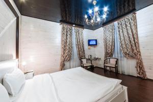 - une chambre avec un lit, une table et des chaises dans l'établissement Hotel Kupecheskiy Dom, à Tomsk