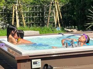two children in a bath tub with a sink at 九十九里 チェックイン14時 1棟貸 BBQ無料 ジャグジー サウナ 焚火 Re Base Shirako in Shirako