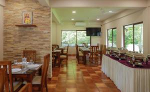a restaurant with tables and chairs and a brick wall at River Whisper Villa in Cochin