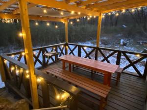a wooden deck with a bench and lights on it at コテージオギー in Nasu