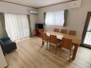 a living room with a wooden table and chairs at コテージオギー in Nasu