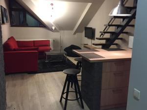 sala de estar con sofá rojo y escalera en Two Level Apartment near Gondola, en Gudauri