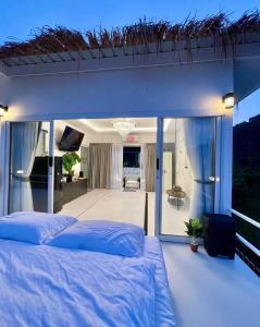 una camera da letto con un grande letto e un balcone di บ้านสวนจมูกโต a Ban Pha Mi