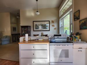 a kitchen with a white stove top oven next to a window at Amitabha Wine Country Cottage in Santa Rosa