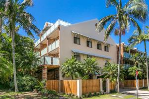 a house with palm trees in front of it at The Terraces Main Beach in Byron Bay