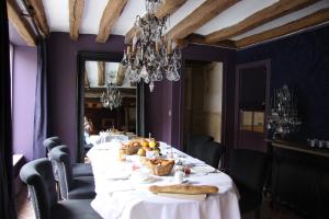 a dining room with a long table with food on it at L'Hibernie in Rochefort-en-Yvelines