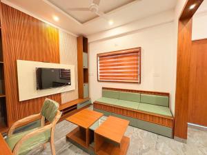 a living room with a table and a tv at Pullat Suites in Kalpetta