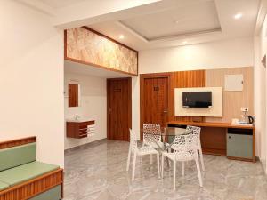 a kitchen with a table and chairs in a room at Pullat Suites in Kalpetta