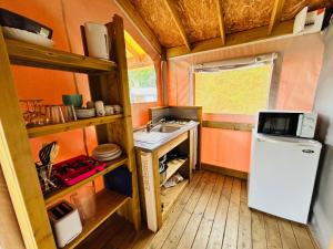 a small kitchen with a sink and a refrigerator at Camping L'Amandier in Gigors