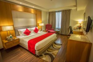 Habitación de hotel con cama y TV en Sarovar Portico- Jalandhar, en Jalandhar