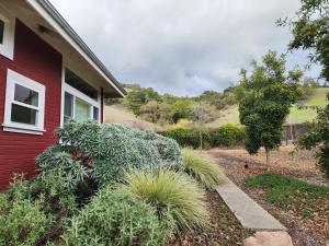 a red house with plants on the side of it at Amitabha Wine Country Cottage in Santa Rosa +7 photos