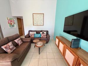 a living room with couches and a flat screen tv at Happy Oasis Second Floor Condo with Terrace in Coco