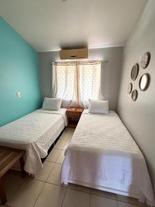 a bedroom with two beds and a window at Happy Oasis Second Floor Condo with Terrace in Coco