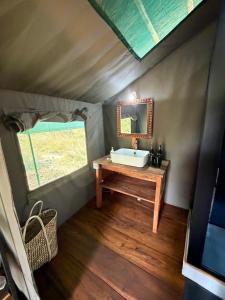 a bathroom with a sink and a mirror at Tangi Elephant Camp in Pakwach East