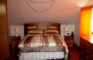 a bedroom with a bed with two night stands and two lamps at Casa Plaza Los Caballos in Olmué +86 photos