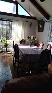 a dining room table with chairs and a vase of flowers on it at Casa Plaza Los Caballos in Olmué