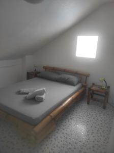 a bedroom with a bed with a phone on it at Koa's Beach House in Tangalan