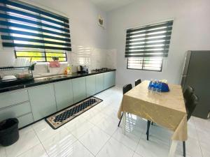 a kitchen with a table and a counter top at Homestay Babah in Jitra