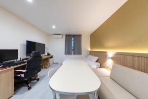 a room with a bed and a desk with a computer at Agabara Gangneung in Gangneung