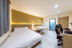 a hotel room with a bed and a table and chairs at Agabara Gangneung in Gangneung