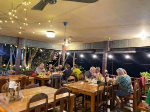 a group of people sitting at tables in a restaurant at Anouxa Riverview Guesthouse in Champasak