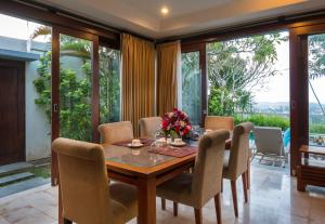 a dining room with a table and chairs at The Kawan Jimbaran in Jimbaran