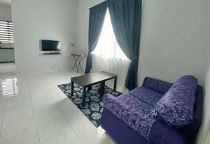 a living room with a purple couch and a table at Homestay Babah in Jitra