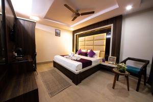 a bedroom with a bed with purple pillows at Hotel Grey Castle - Near Haridwar Railway Station in Haridwār +28 photos