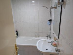 a bathroom with a white tub and a sink at Elegant Double Room in Abu Dhabi