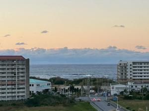 a view of the ocean from a city with buildings at オランウータンApple House Ginowan in Ginowan