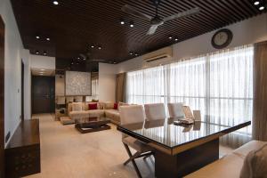 a living room with a table and chairs and a clock at Theory9 Premium Service Apartments Khar in Mumbai